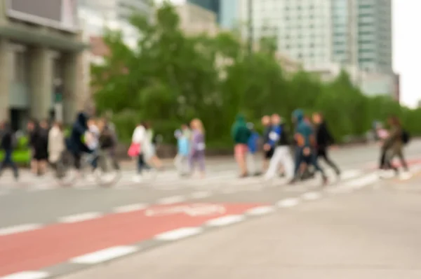 People crossing street in city, blurred view