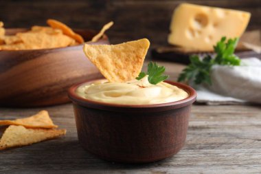 Tahta masada nacho ve maydanozlu nefis peynir sosu, yakın plan.