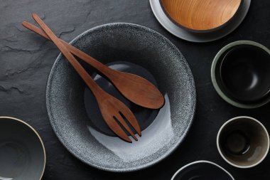 Set of clean tableware on black table, flat lay