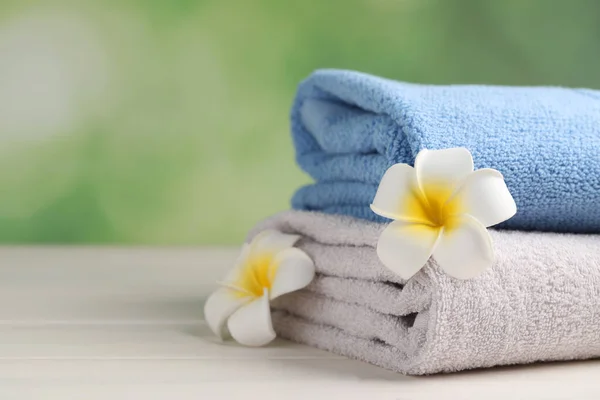 Closeup View Soft Folded Towels Plumeria Flowers White Wooden Table —  Fotos de Stock