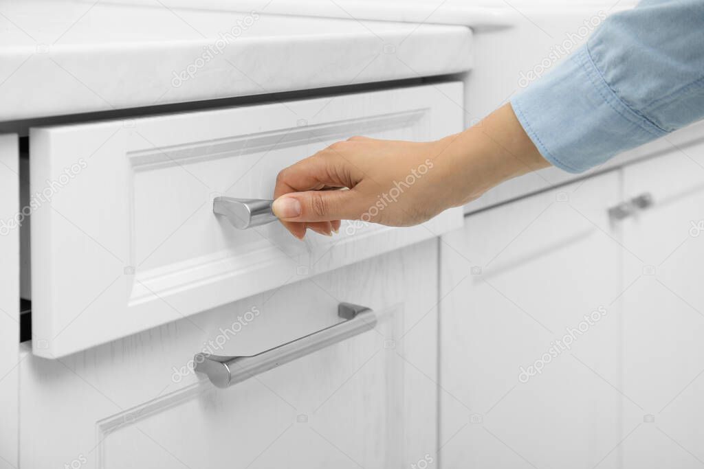 Woman opening drawer at home, closeup view
