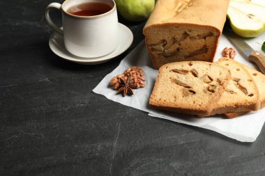 Composition with tasty pear bread on black slate table. Homemade cake