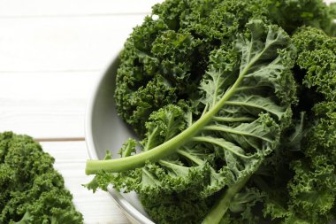 Fresh kale leaves on white table, closeup