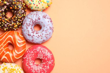 Turuncu arka planda nefis jöleli donutlar, düz yatış. Metin için boşluk