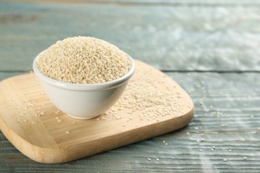 Açık mavi ahşap masada beyaz susam tohumları