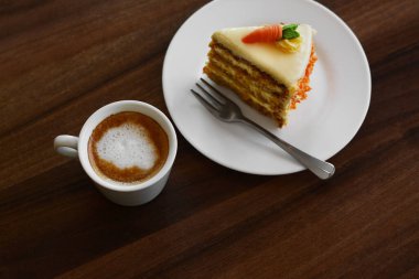 Delicious cake and cup of hot coffee on wooden table, above view