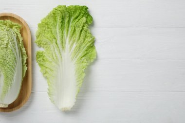 Fresh ripe Chinese cabbage and leaf on white wooden table, flat lay. Space for text