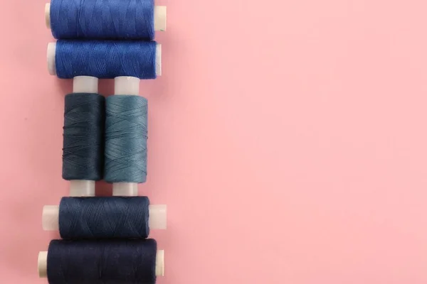 ピンクの背景に青の縫製糸の異なる色合い フラットレイ テキストのスペース — ストック写真