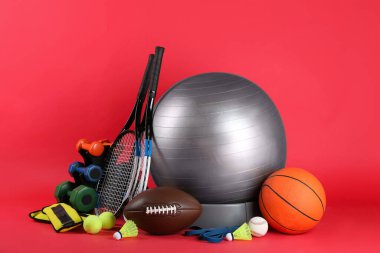 Set of different sports equipment on red background