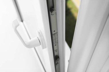 Above view of open window with white plastic frame indoors, closeup