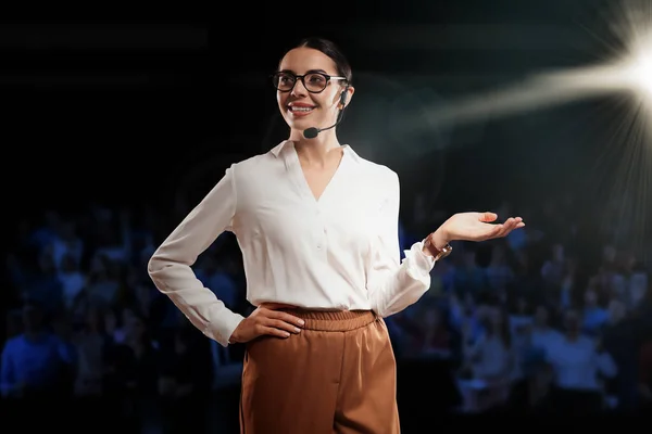 Motivational speaker with headset performing on stage