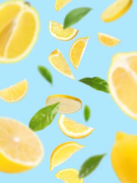Свежие Спелые Лимоны Зеленые Листья Падают Голубом Фоне — стоковое фото