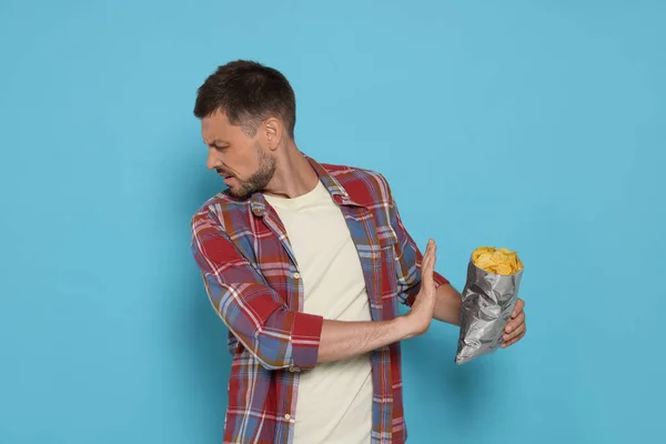Handsome Man Refusing Eat Potato Chips Light Blue Background — Stock Photo, Image
