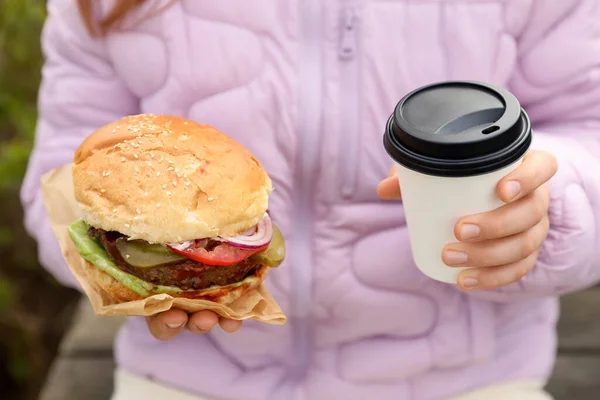 Little Girl Holding Fresh Delicious Burger Cup Coffee Outdoors Closeup — Fotografia de Stock