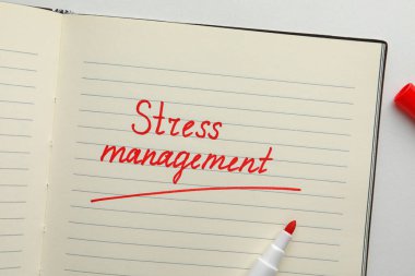 Notebook with words Stress Management and marker on white background, flat lay