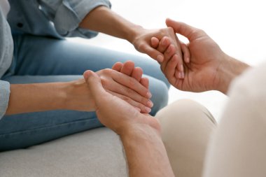 Dindar insanlar el ele tutuşup kapalı yerlerde dua ediyorlar.