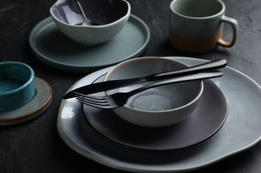 Set of clean tableware on black table