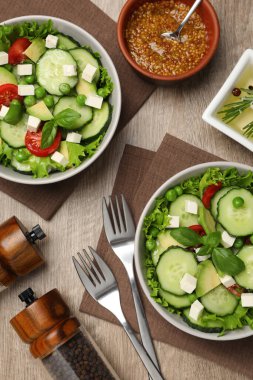Tasty fresh salad with cucumber served on wooden table, flat lay