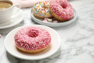 Yummy donut with sprinkles on white marble table