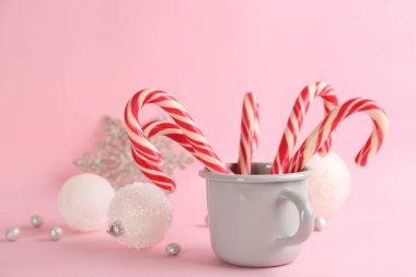 Candy canes and Christmas balls on pink background