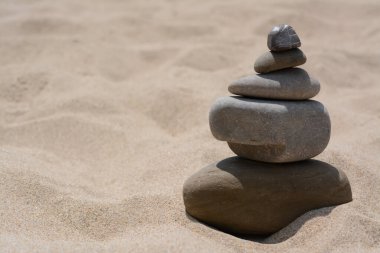 Stack of stones on beautiful sandy beach, space for text