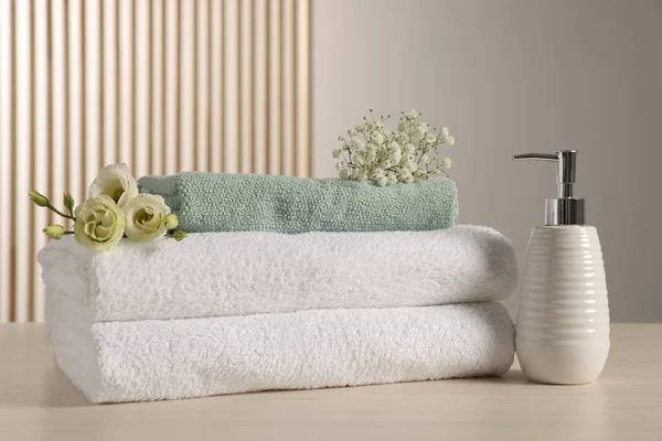 Soft Folded Towels Dispenser Gypsophila Eustoma Flowers Light Wooden Table — Fotografia de Stock