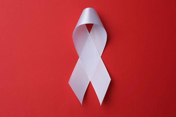 White Awareness Ribbon Red Background Top View — Stockfoto