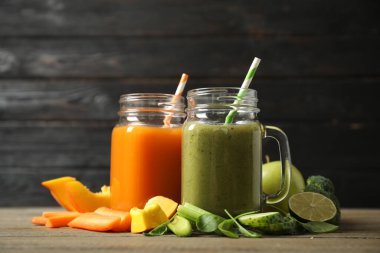 Lezzetli sebze suları ve ahşap masada taze malzemeler.