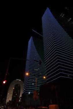 BATUMI, GEORGIA - JUNE 09, 2022: Night cityscape with illuminated buildings, low angle view