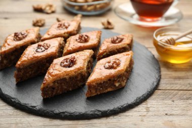 Ahşap masada sunulan cevizli lezzetli bal baklavası, yakın plan.