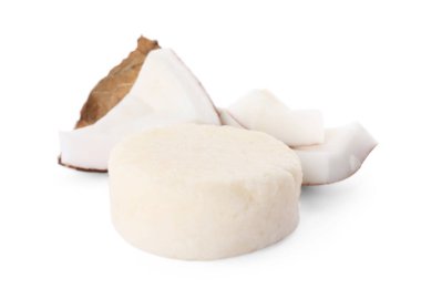 Solid shampoo bar and coconut pieces on white background. Hair care