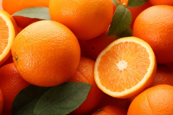 Вырезать Целые Свежие Спелые Апельсины Зелеными Листьями Качестве Фона Крупным — стоковое фото