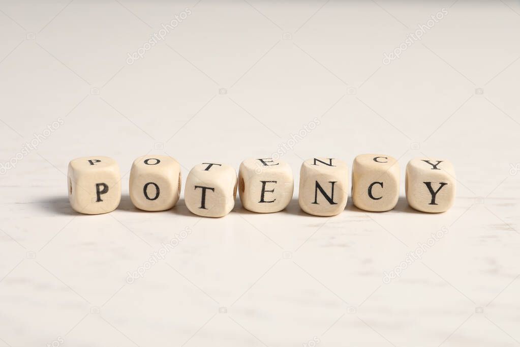 Wooden cubes with word Potency on white table, closeup