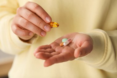Young woman with dietary supplement pills, closeup