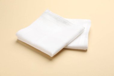 White handkerchiefs on beige background. Stylish accessory