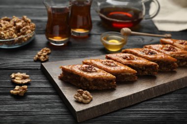 Delicious sweet baklava with walnuts on black wooden table