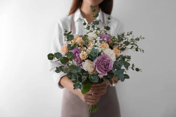 Florist holding beautiful wedding bouquet on white background, closeup