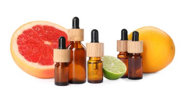 Bottles of different citrus essential oils and fresh fruits on white background