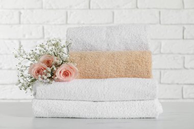 Stack of folded colorful towels with roses on white table