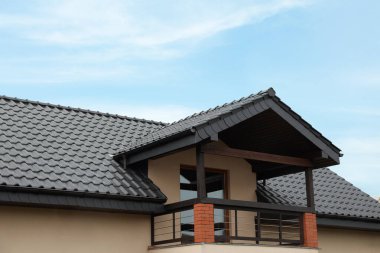 Beautiful house with grey roof against blue sky