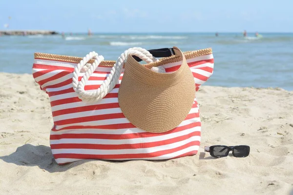 Stylish Striped Bag Visor Cap Sunglasses Sandy Beach Sea — Fotografia de Stock