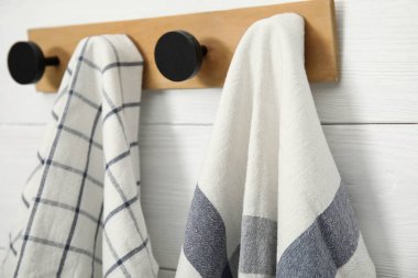 Clean kitchen towels hanging on rack, closeup