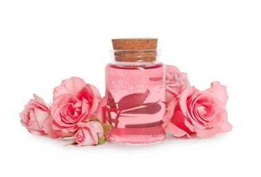Bottle of essential rose oil and flowers on white background