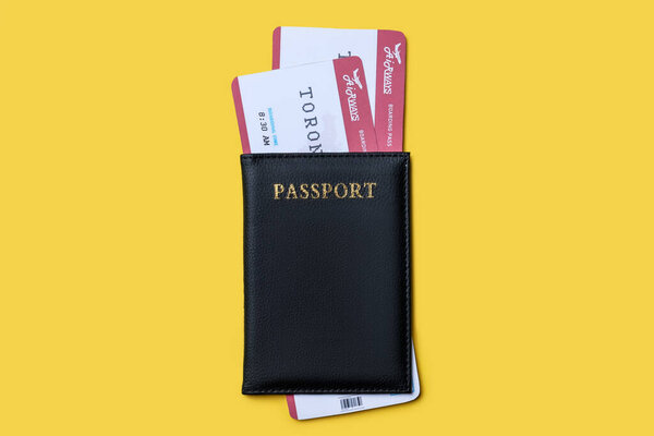Top view of passport with tickets on yellow background. Travel agency concept