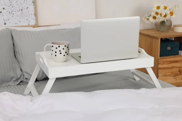 Fehér Tálca Asztal Laptoppal Csésze Itallal Ágyon Beltérben — Stock Fotó