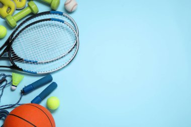 Set of different sports equipment on light blue background, flat lay. Space for text