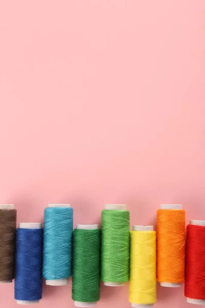 Diversi Fili Colorati Cucire Sfondo Rosa Posa Piatta Spazio Testo — Foto Stock
