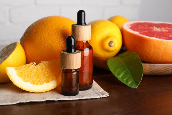 Bottles Essential Oils Different Citrus Fruits Leaf Wooden Table Closeup — Stok fotoğraf