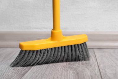 Plastik süpürge ile ahşap zemin süpürüp, yakın plan