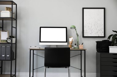 Modern bilgisayarlı, masa başında rahat bir ofis sandalyesi.